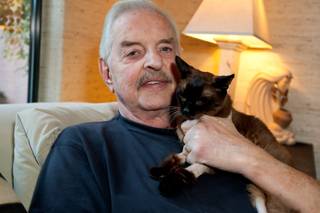 Rick Mills holds his beloved 24-year-old cat, Kia, during her last few days of life at their home in Las Vegas Monday, August 12, 2013.  Kia, a Burmese Siamese, is suffering with pulmonary carcinoma and arthritis, which are taking a fast toll on her health.